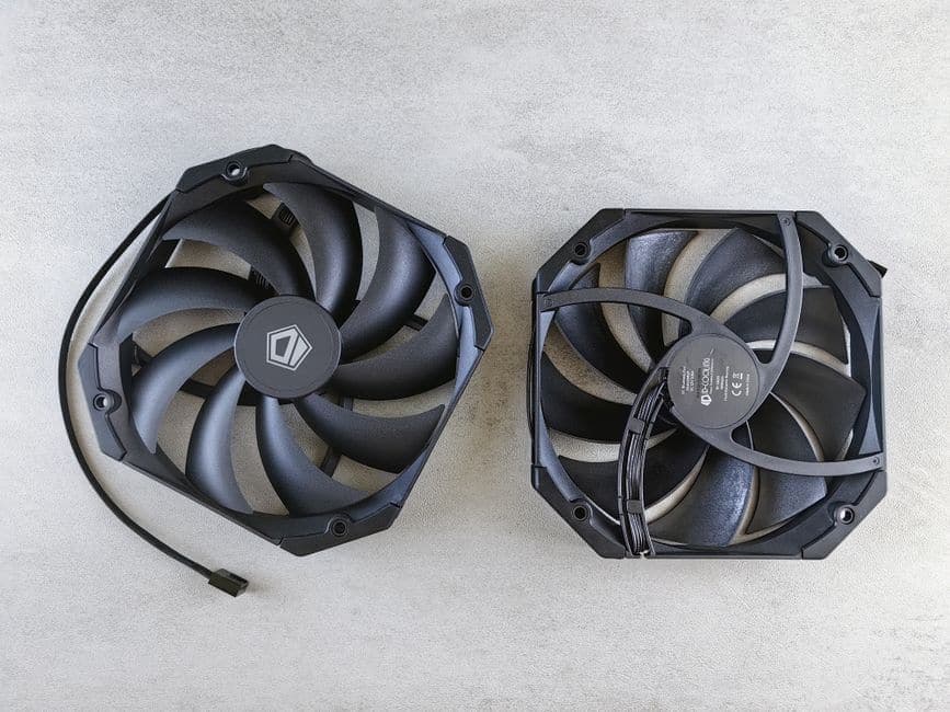 Two black cooling fans seen from above on a gray concrete surface
