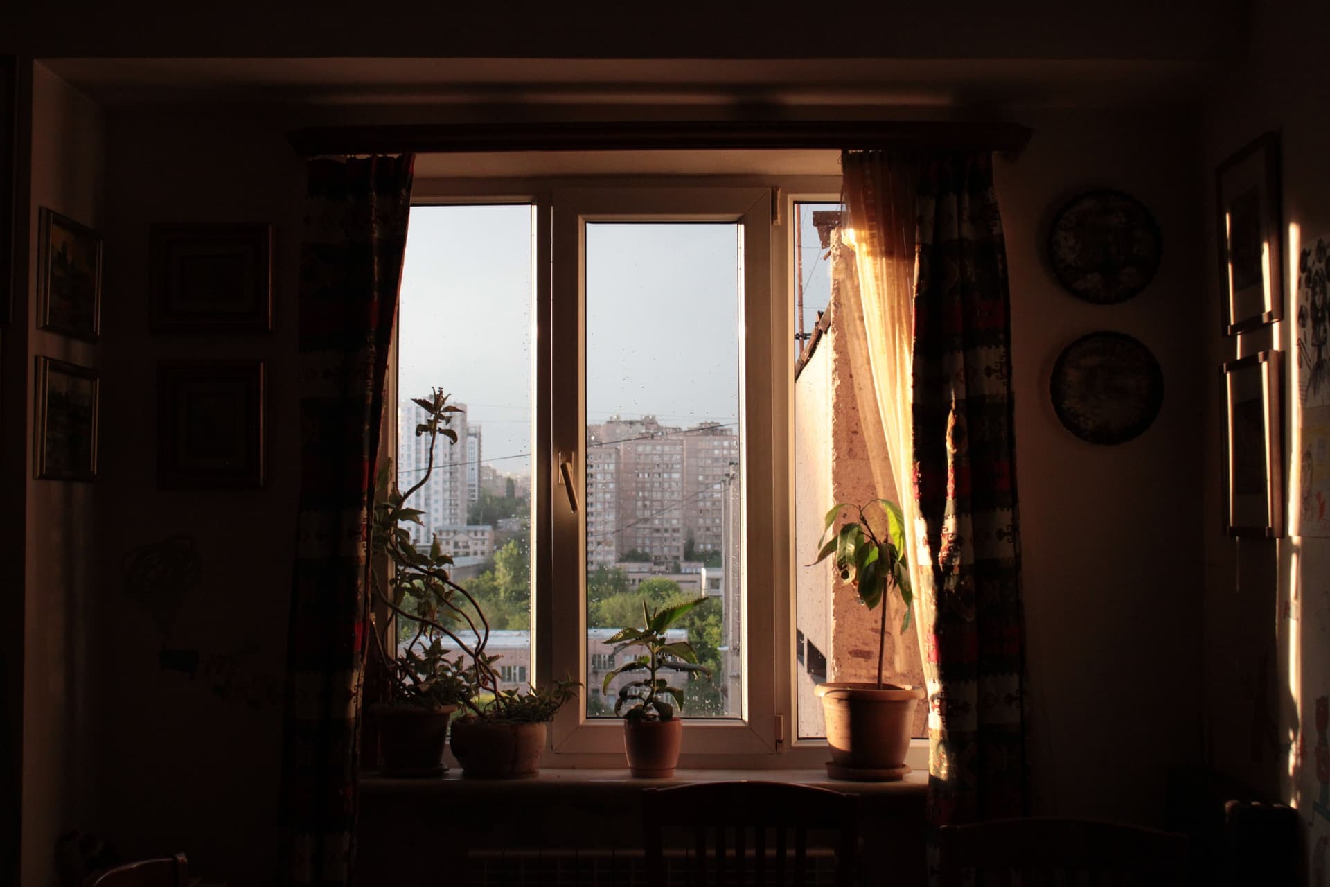 A small apartment interior with a large window looking onto a city