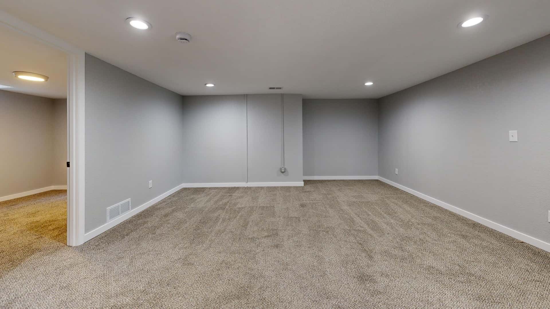 A finished basement room with a small high window