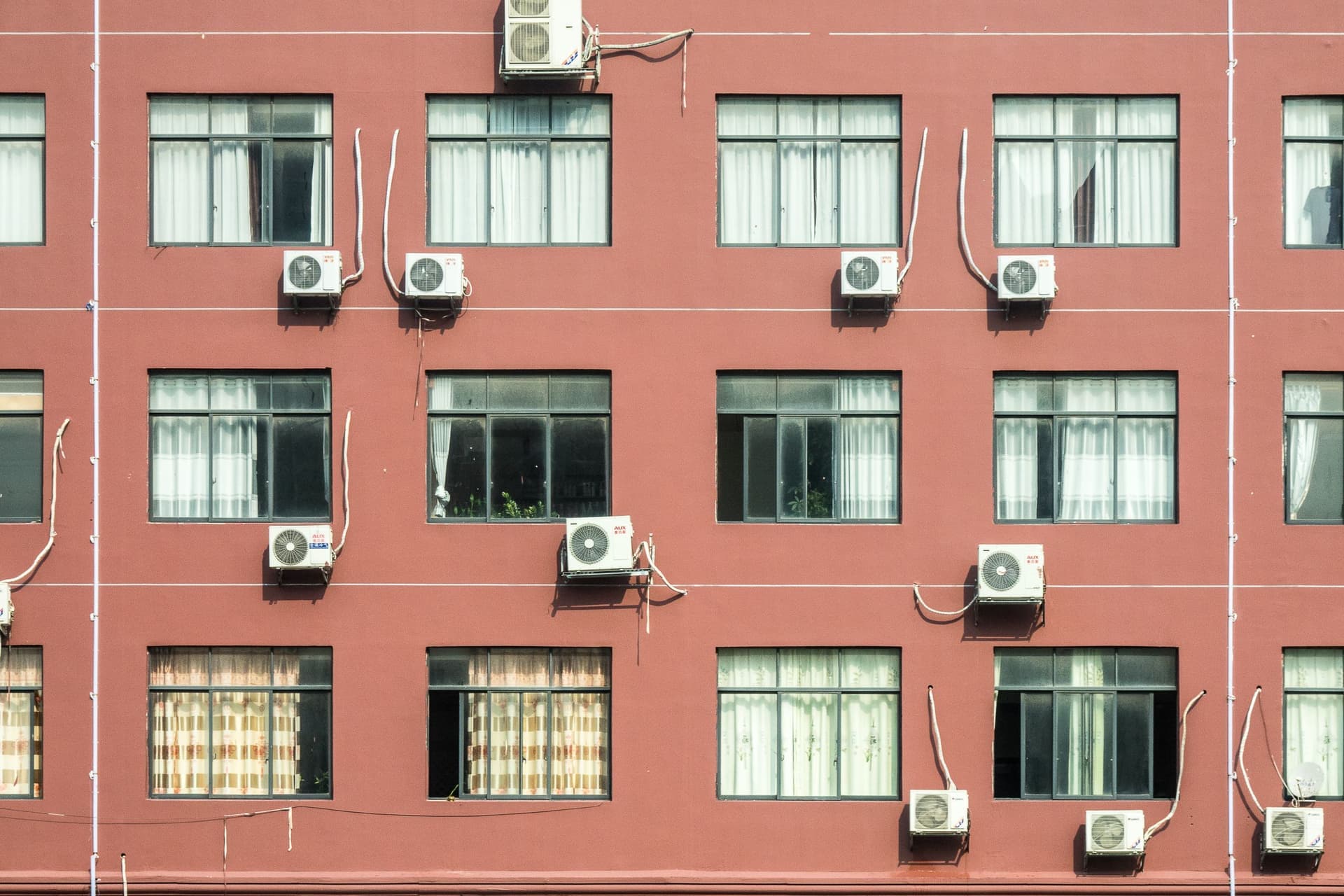 Window air conditioners on the facade of a brick apartment building