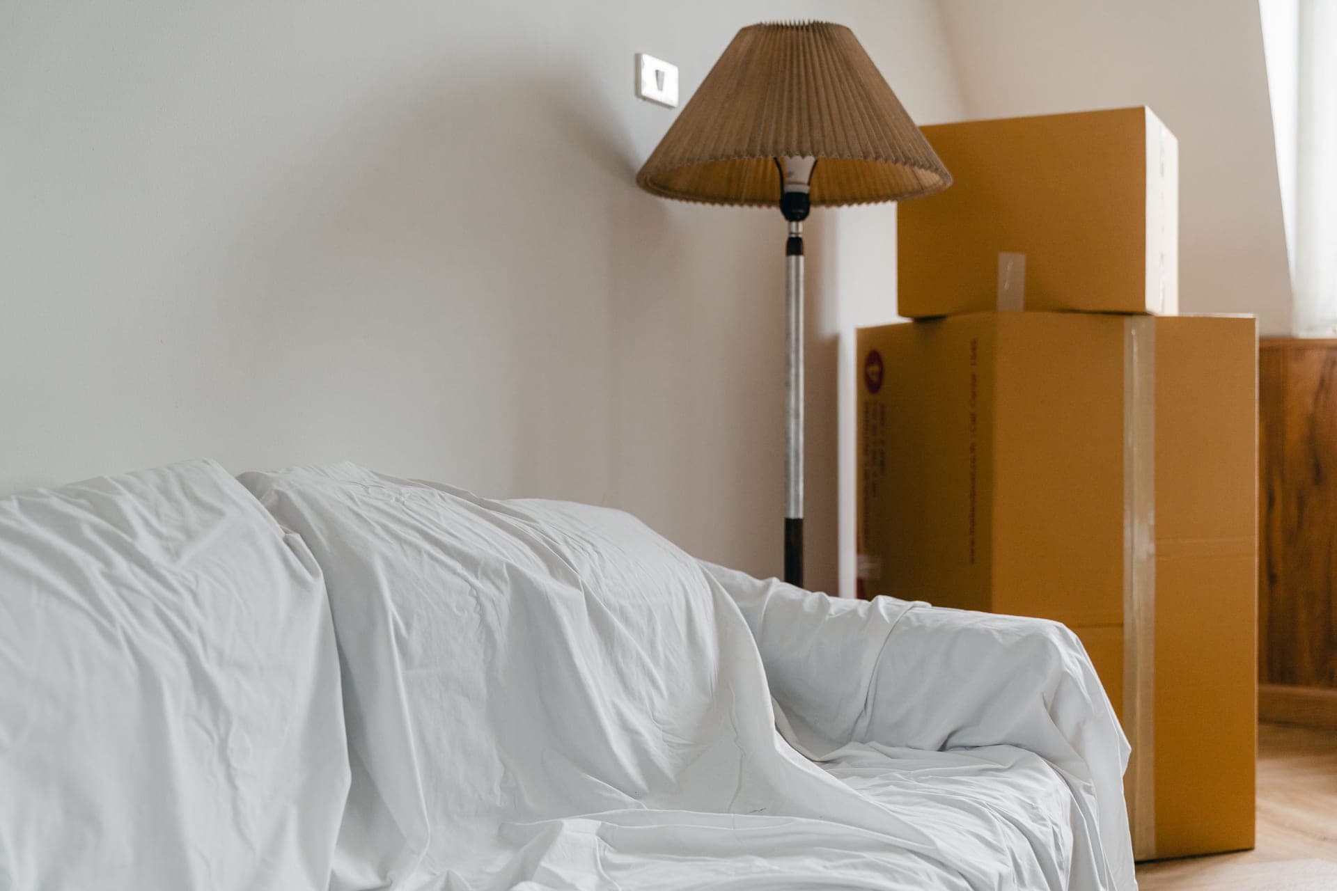 A sparsely furnished rented apartment living room with a large window