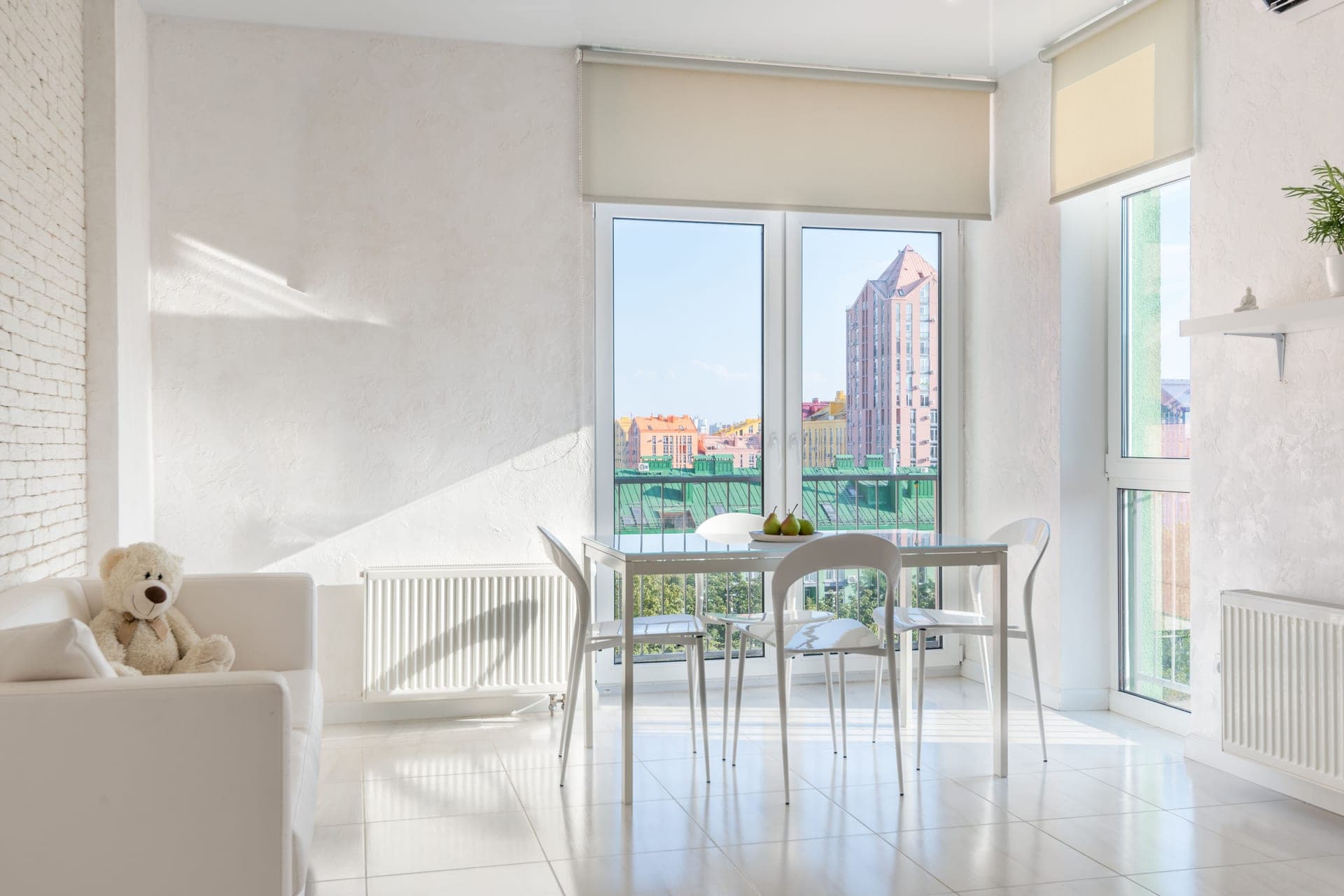 An apartment dining area with balcony doors and a sofa
