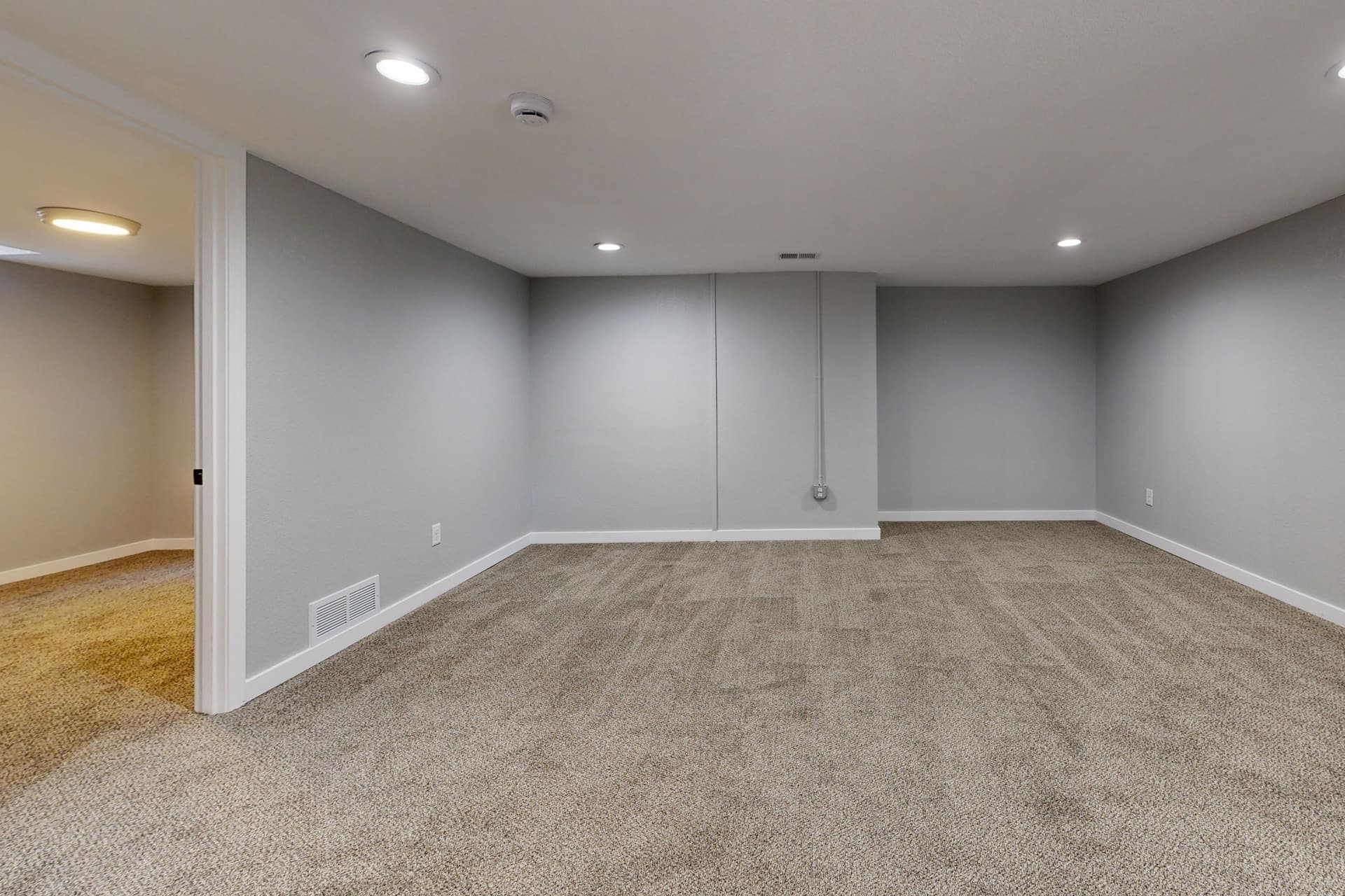 An open below-grade room with bare walls