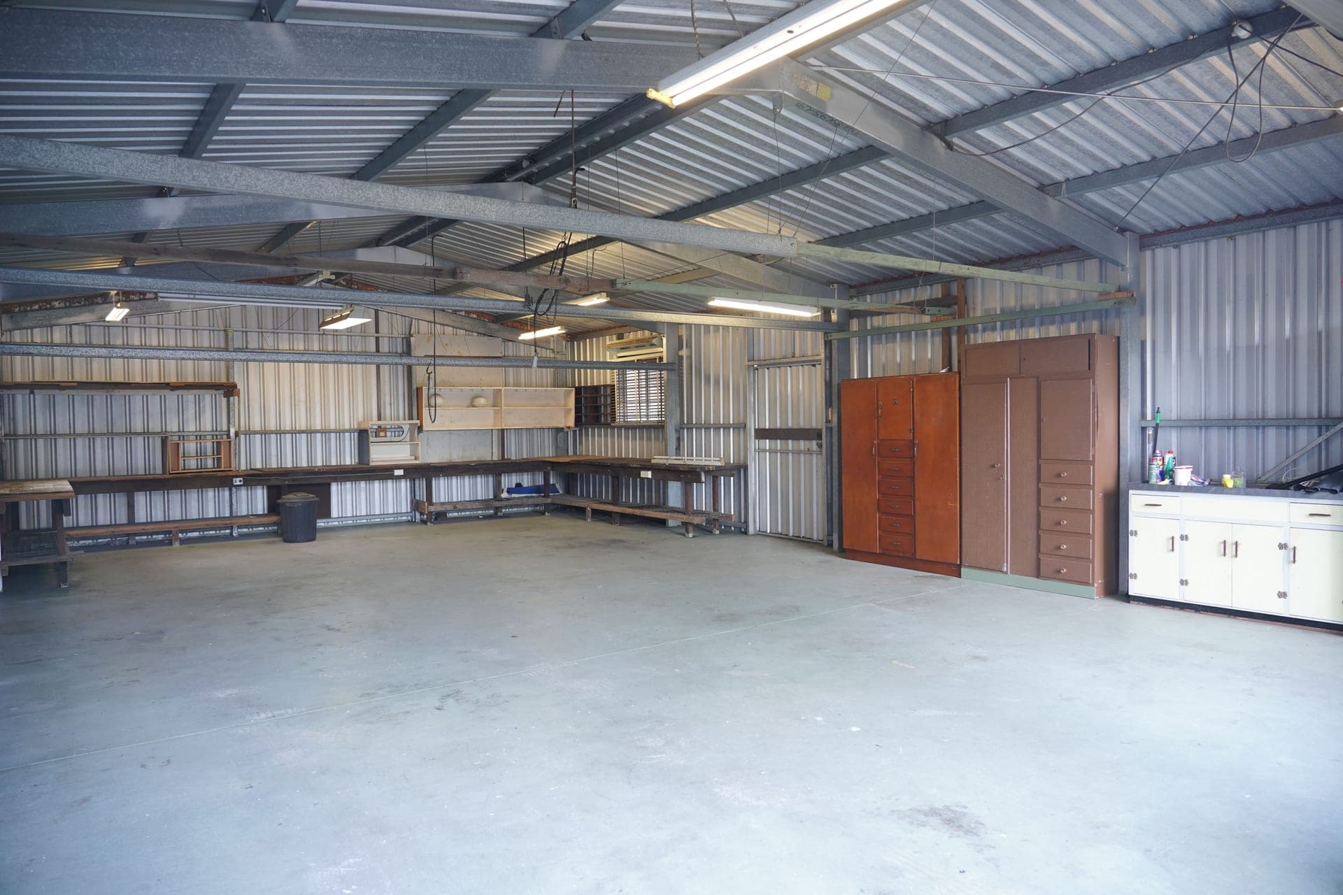 An industrial garage interior with steel walls, cabinets and workbenches