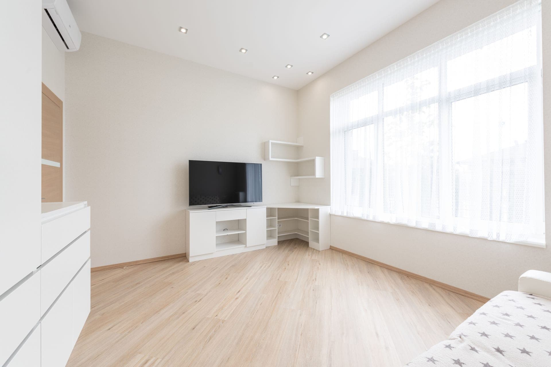 A bright room with white cabinets and a large window