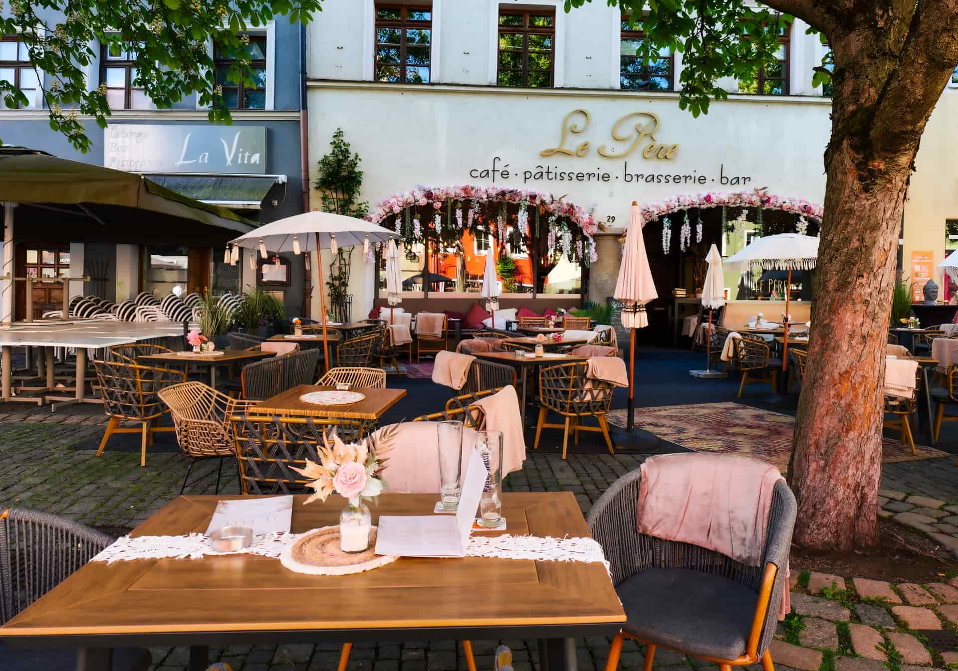 A shaded outdoor patio with seating on a hot summer afternoon