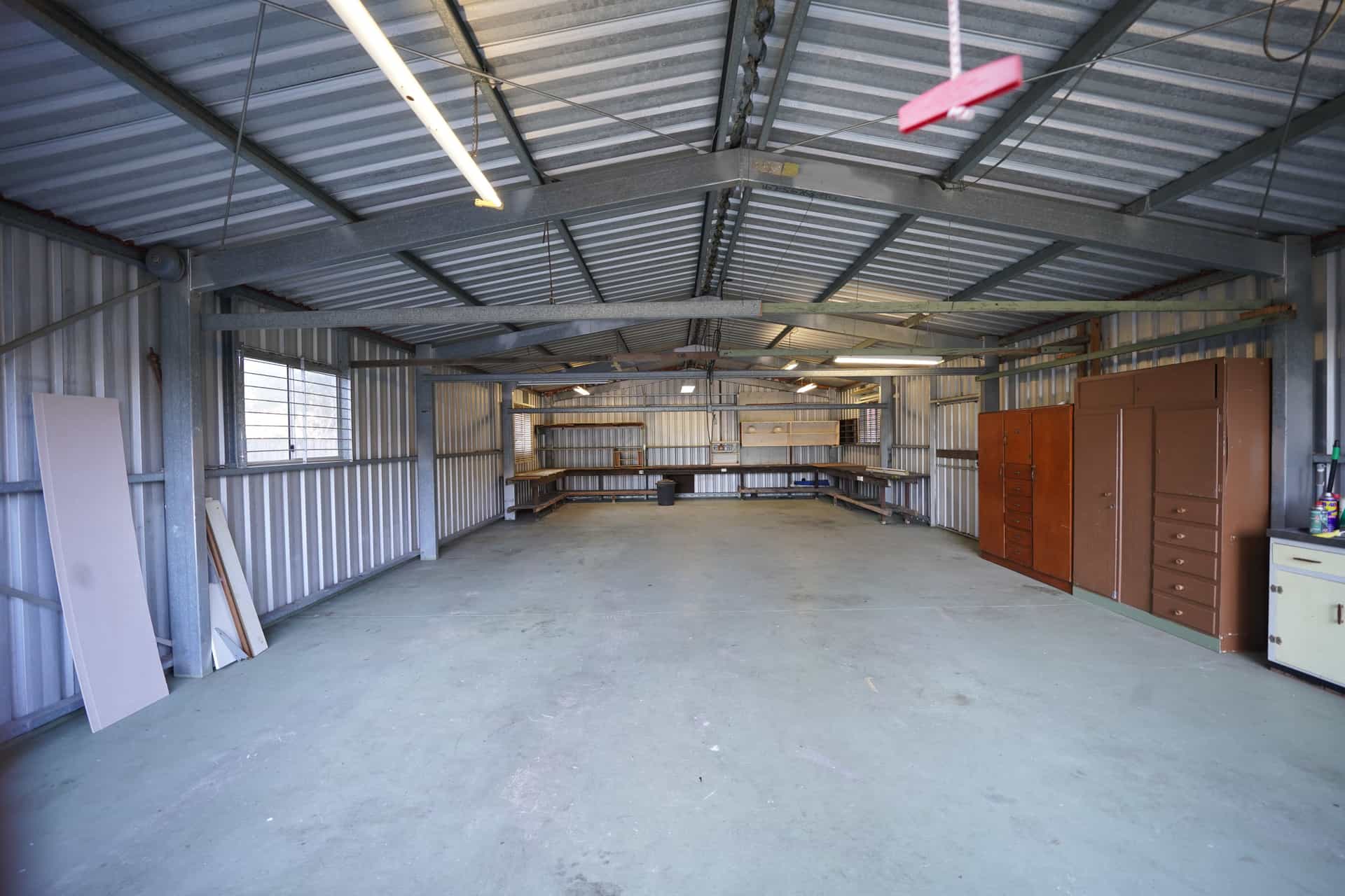 An industrial floor fan on a concrete workshop floor