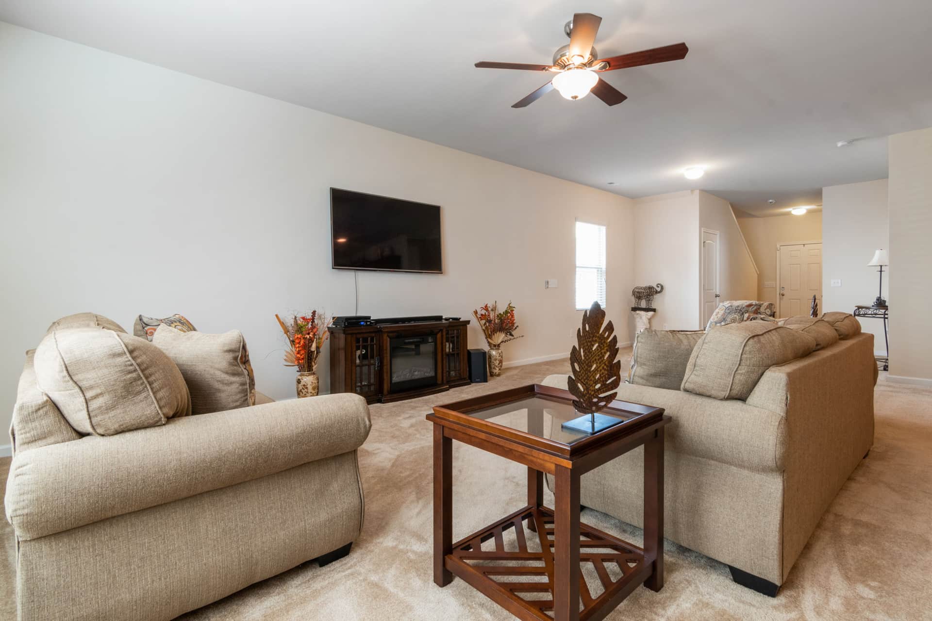 A standing pedestal fan in the corner of a living room