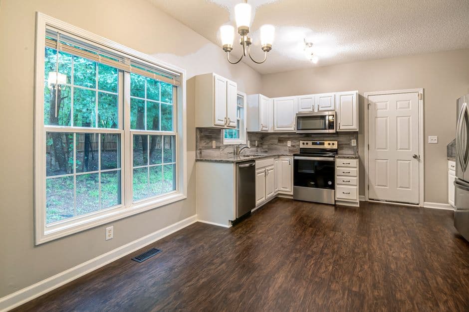 A floor register vent in a home with wooden flooring