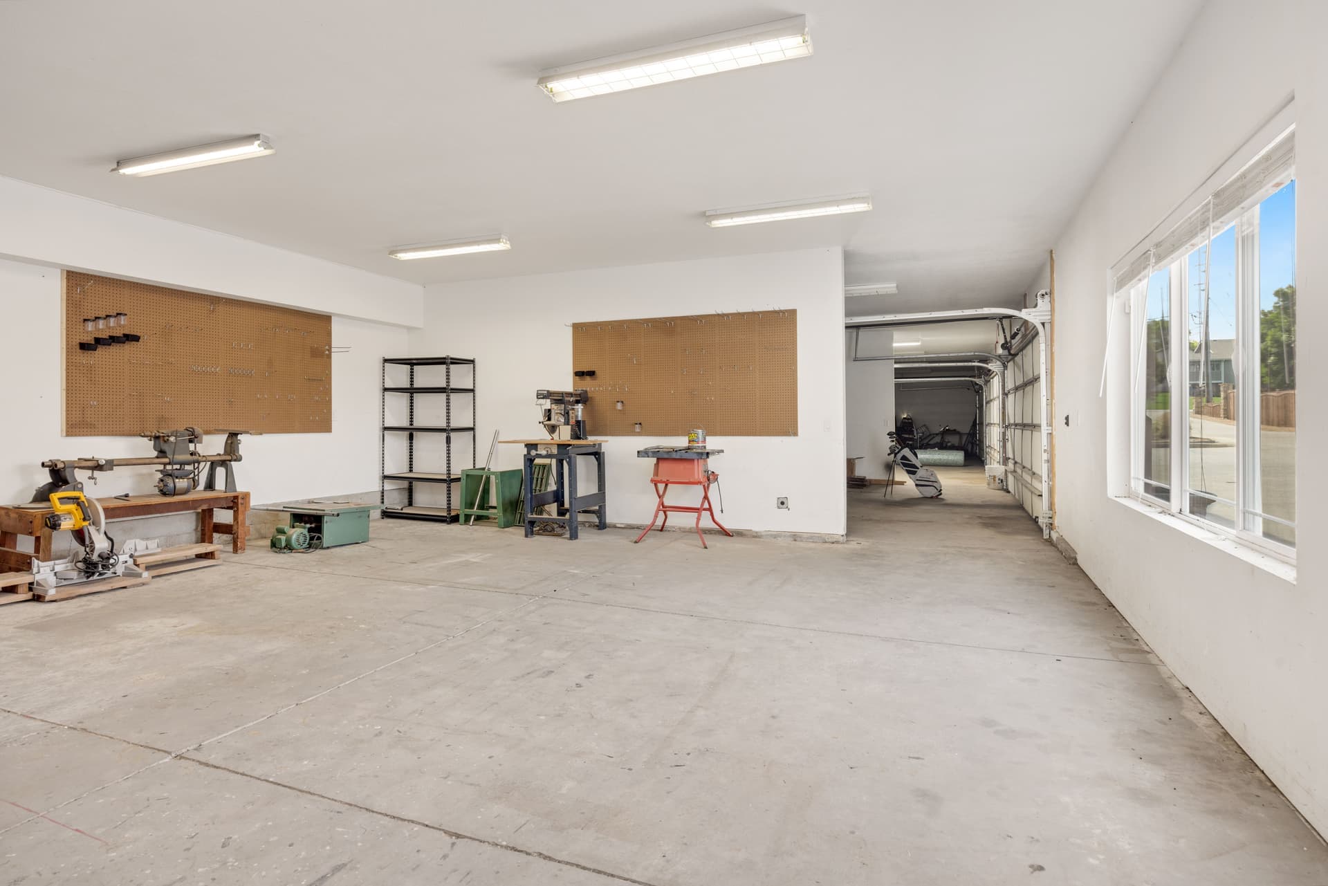 A home garage workshop with tools and the door open to daylight