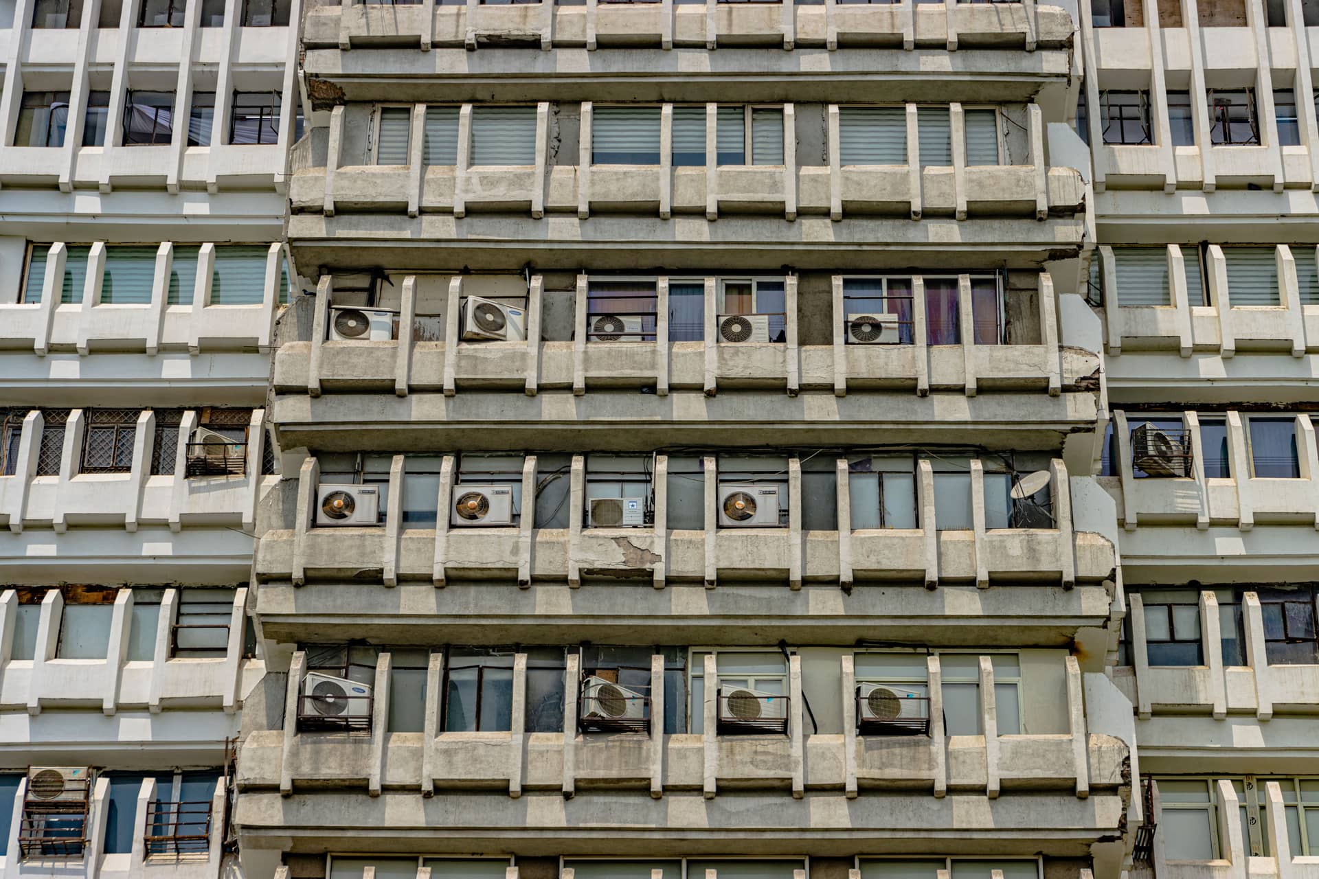 A building facade with many air conditioning units