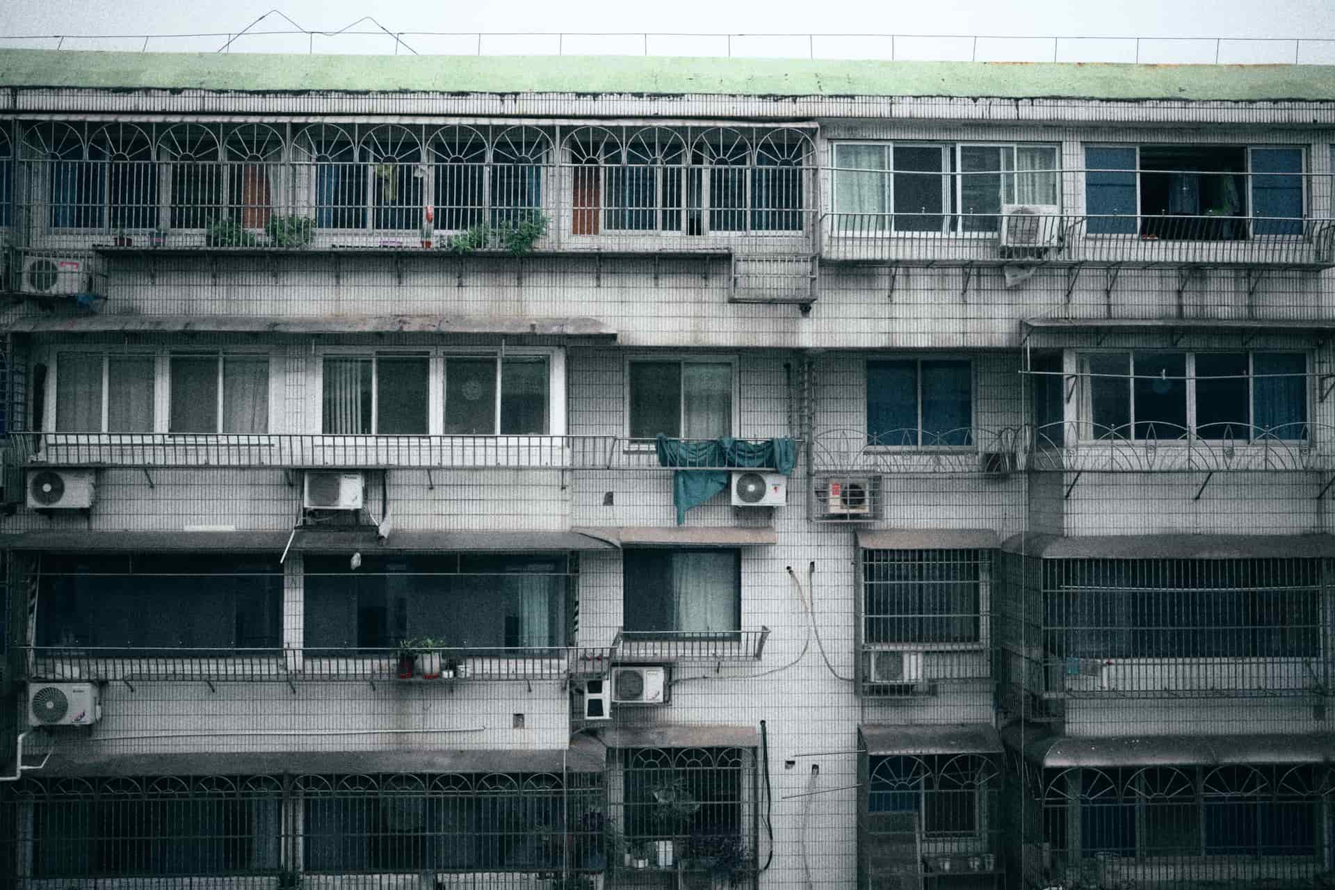 A window air conditioner fitted in the lower sash of an apartment window, seen from inside