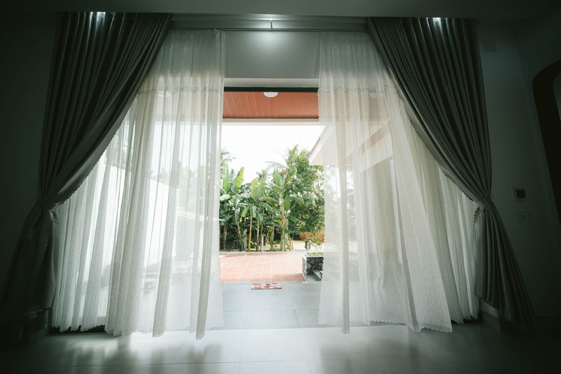 An open window with a curtain moving in the evening air