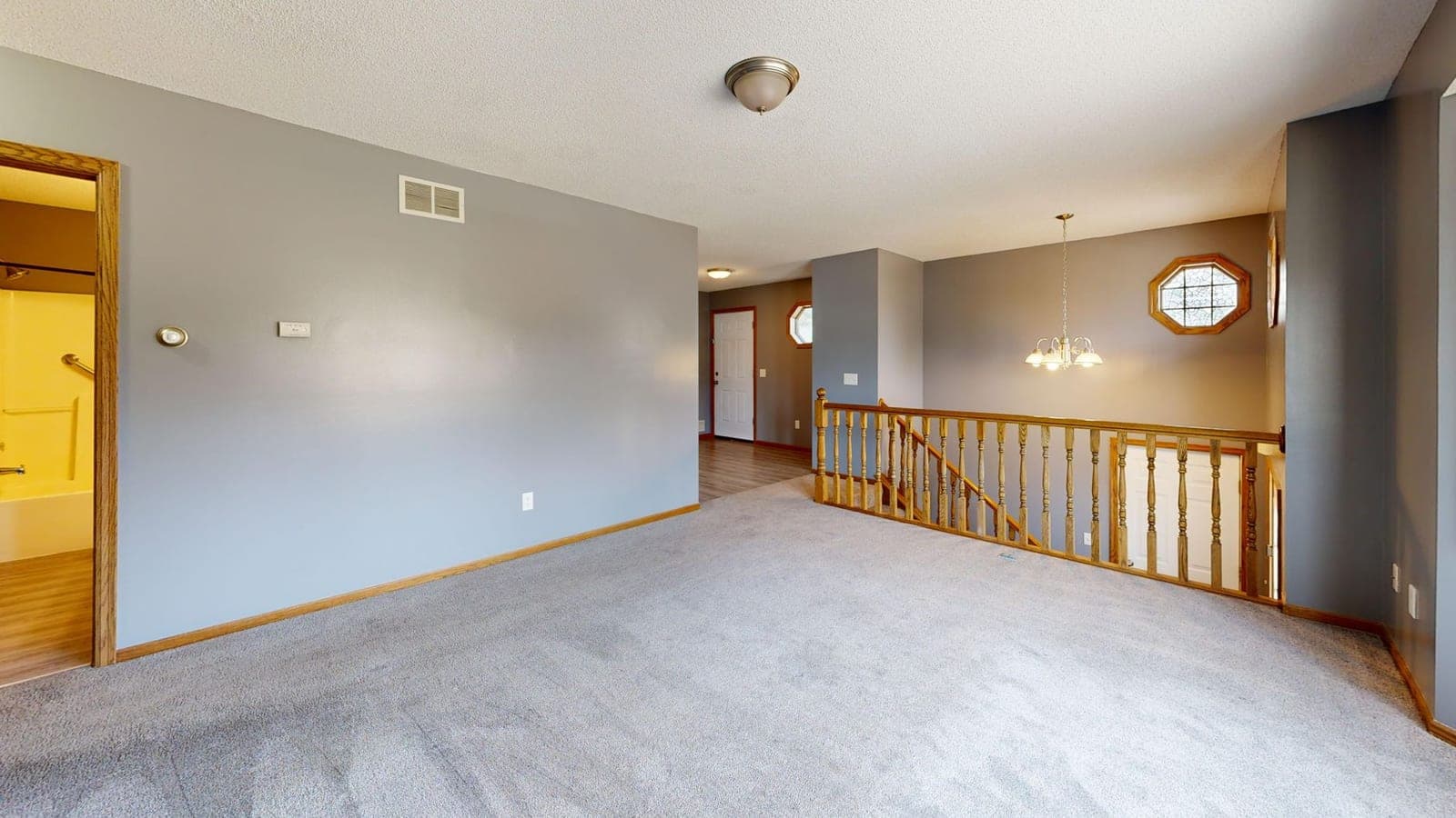 A bright empty carpeted room with natural light