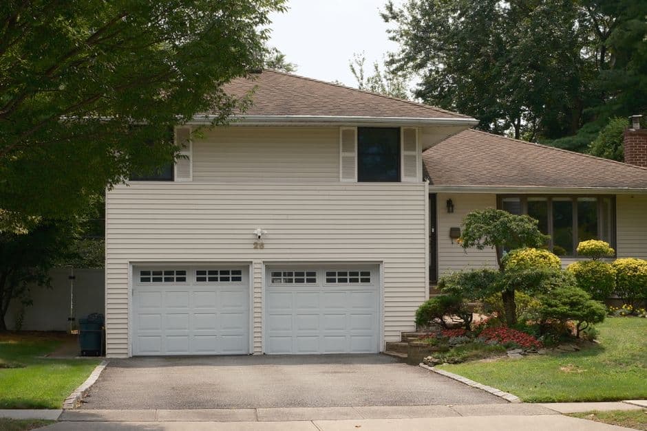 A suburban house with a double garage on a summer day