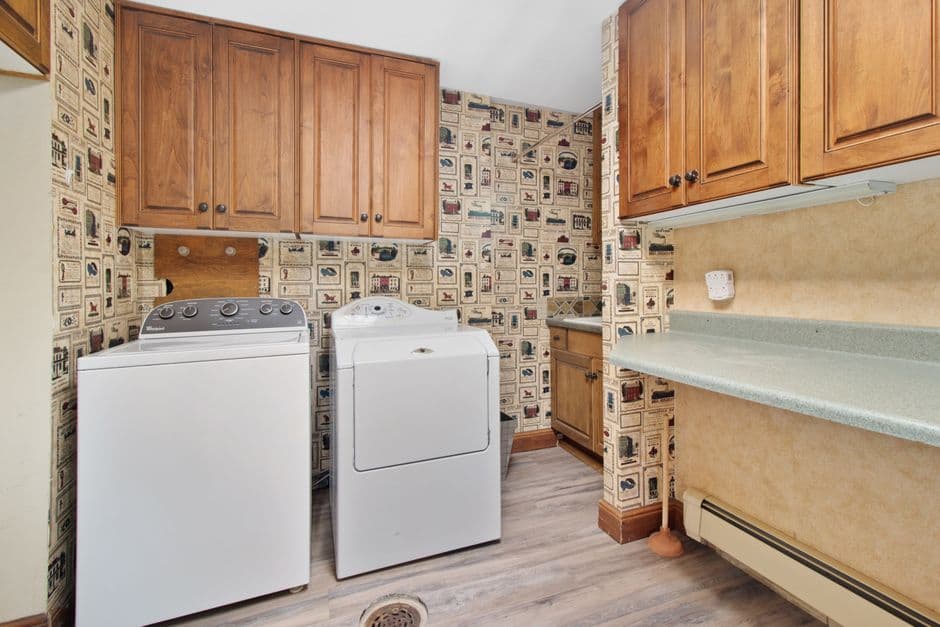 A utility room with a washer and dryer and floor drainage