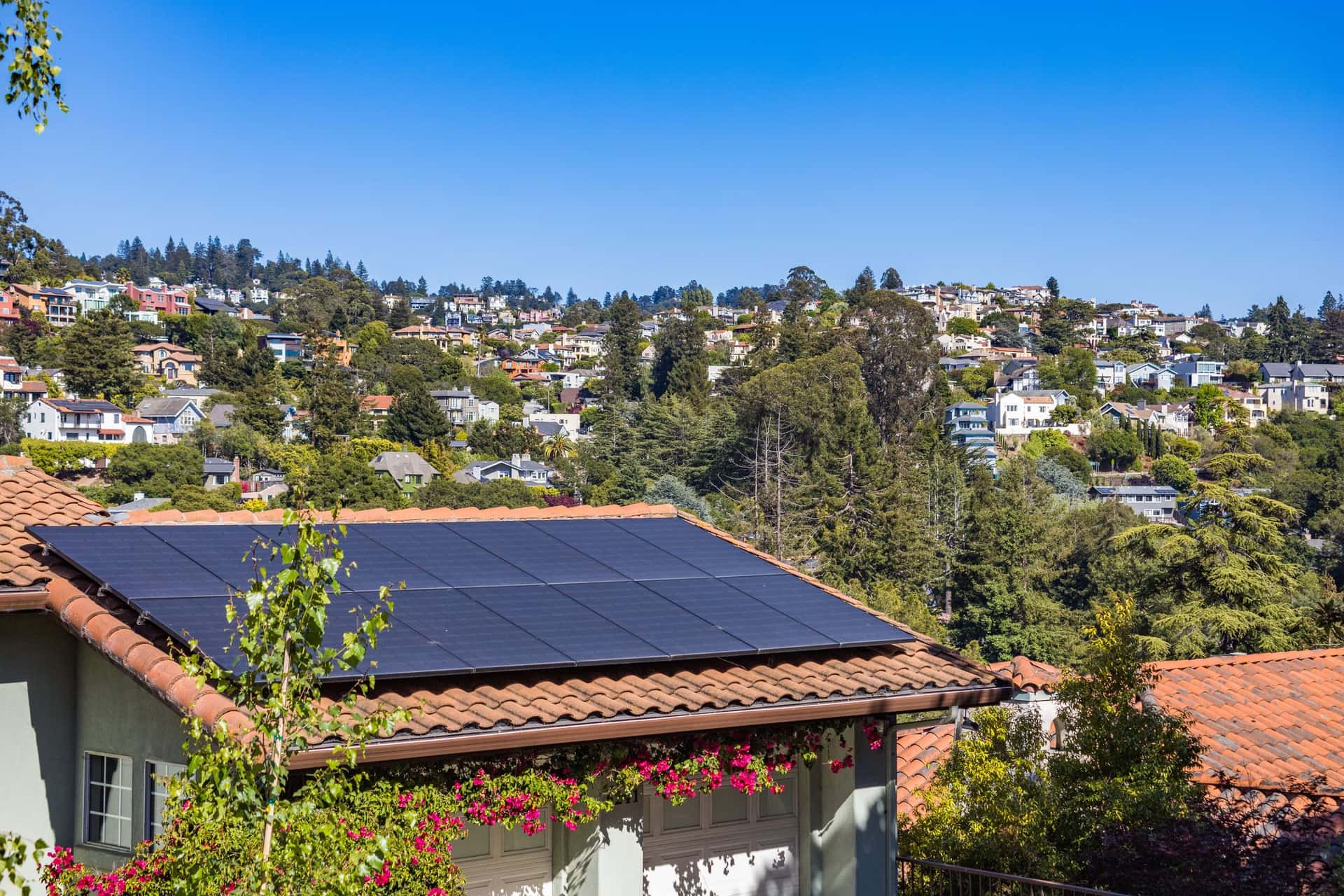 Solar panels on the roof of a suburban house under a clear sky