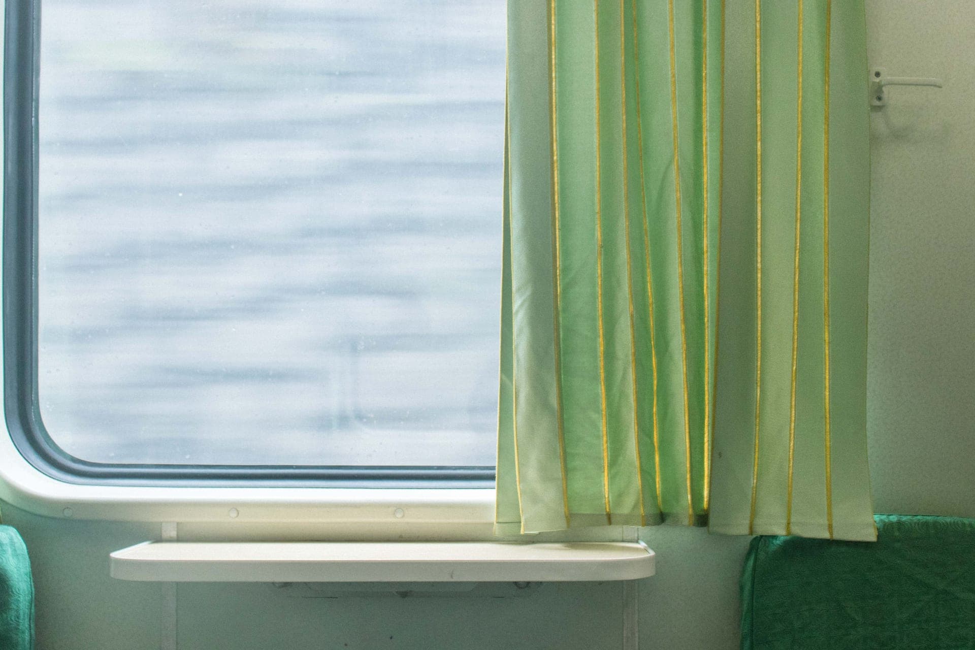 A curtain beside a window, moving in the air