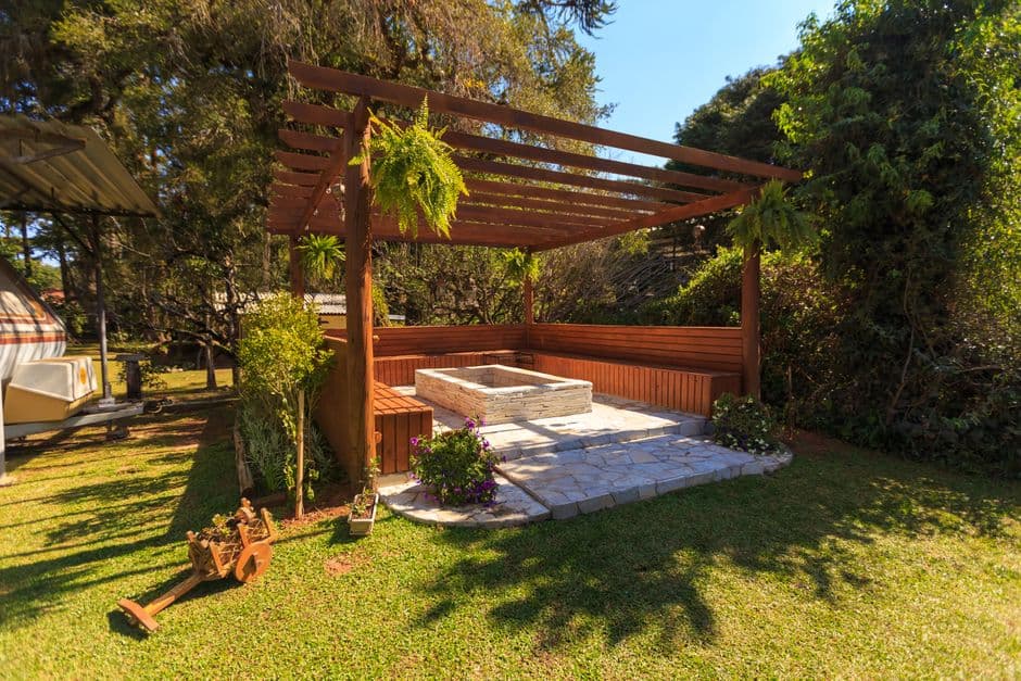A wooden gazebo in a garden on a hot day