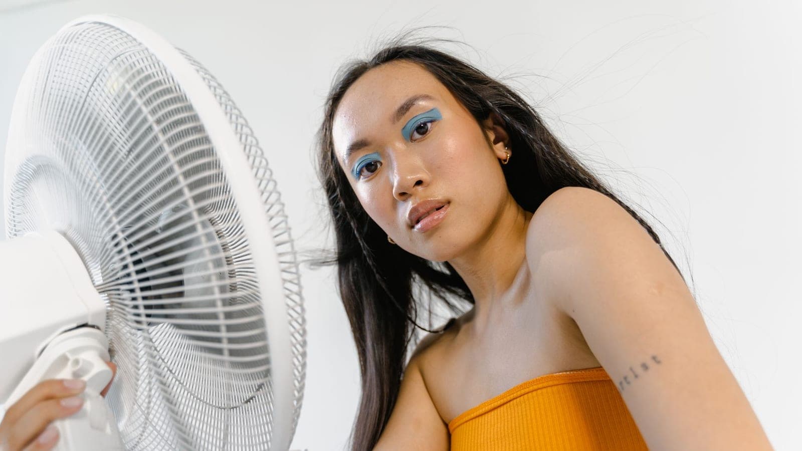 A person relaxing in front of a fan
