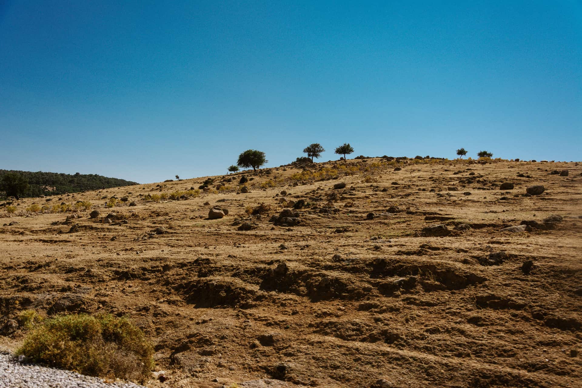 A barren rocky landscape under a clear blue sky