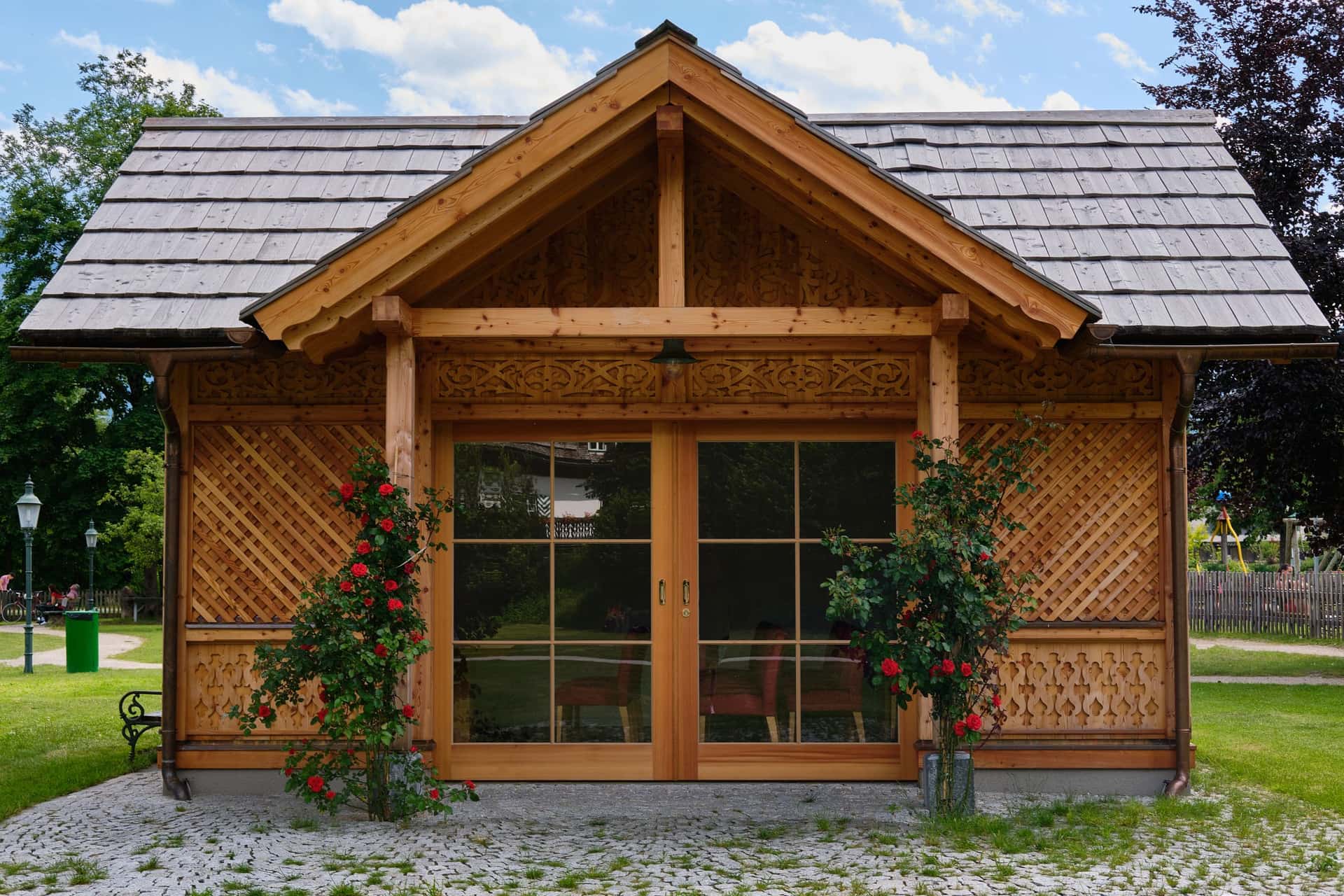 A timber garden building with glazed double doors in a summer garden
