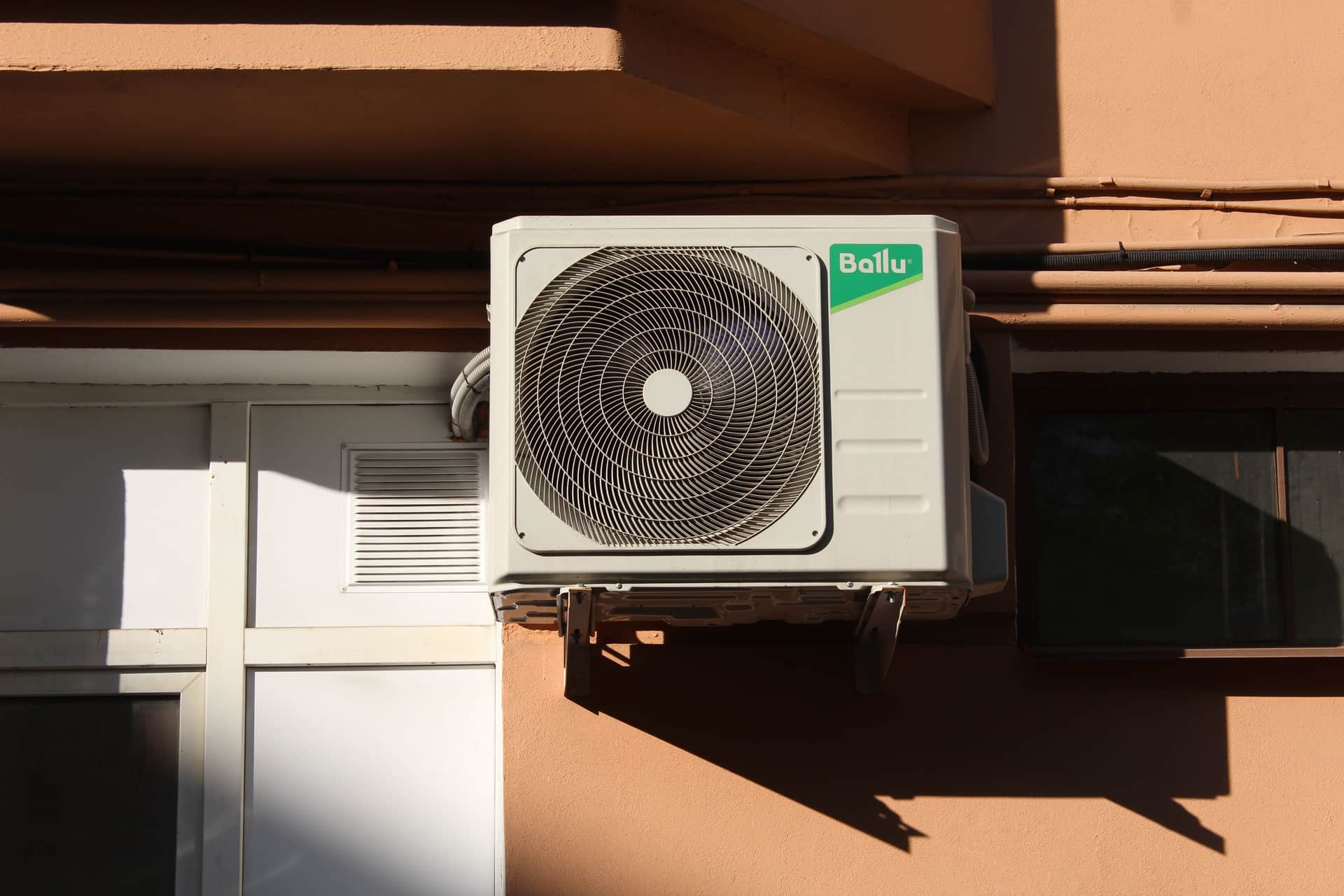 An outdoor condenser unit mounted beside a house wall