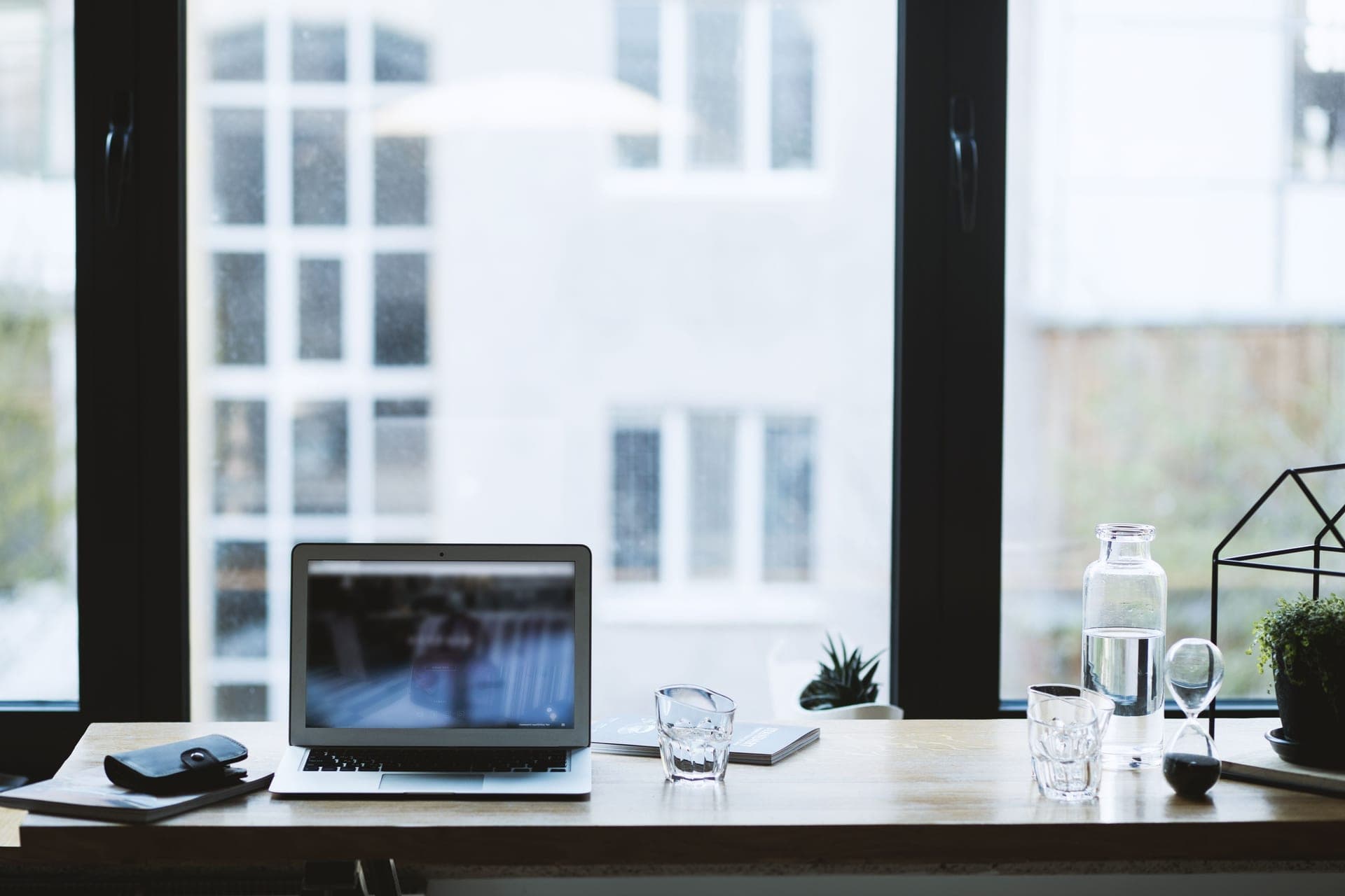 A home office desk with a monitor and a small fan