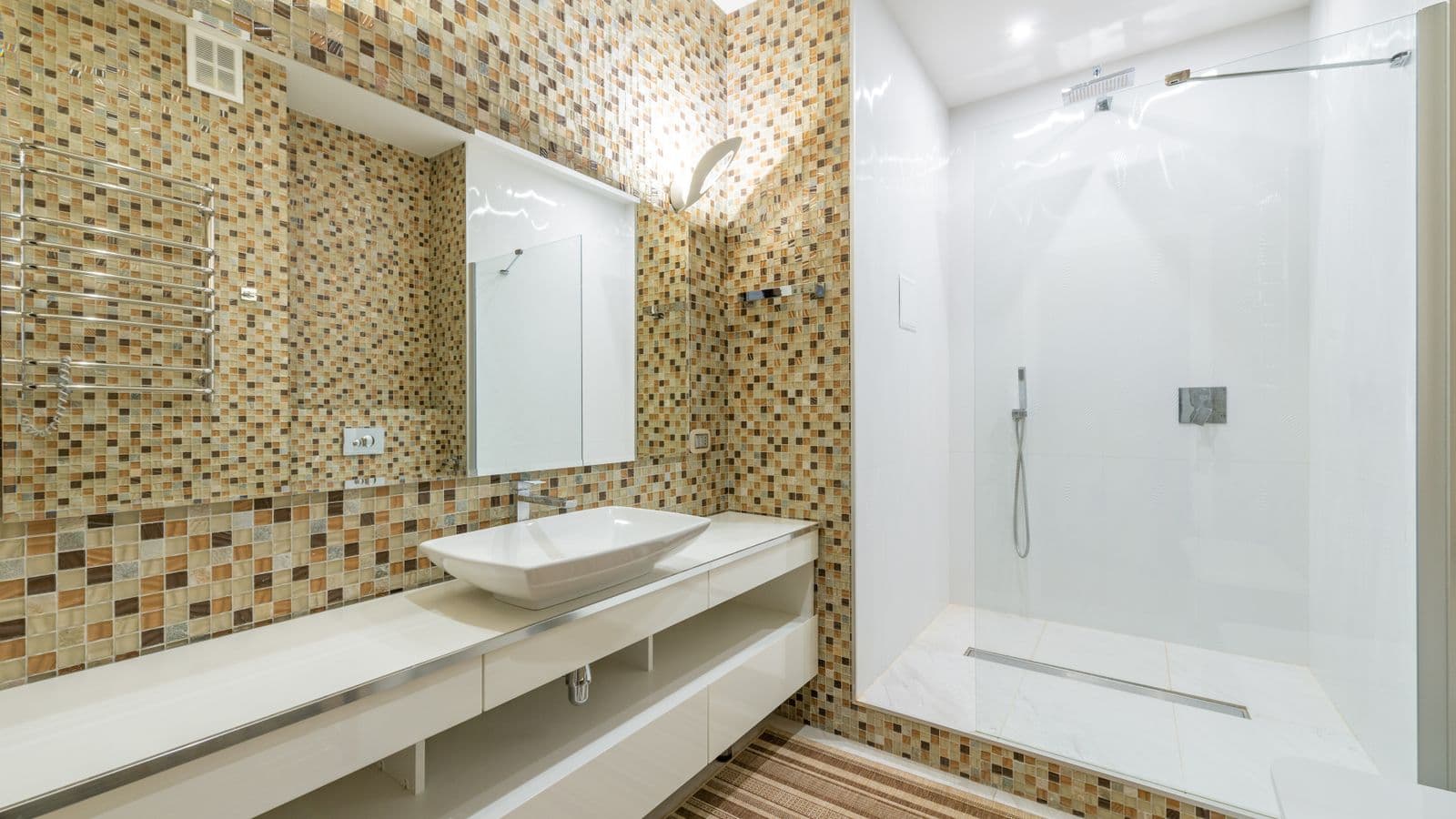 A contemporary bathroom with a shower cabin and a wide mirror above the sink