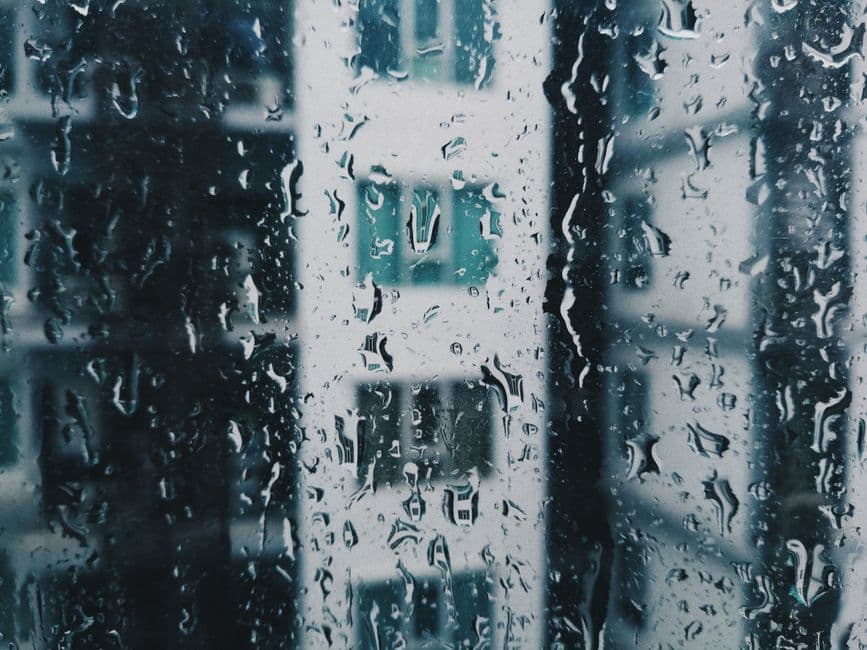 Raindrops on a window with a blurred view behind