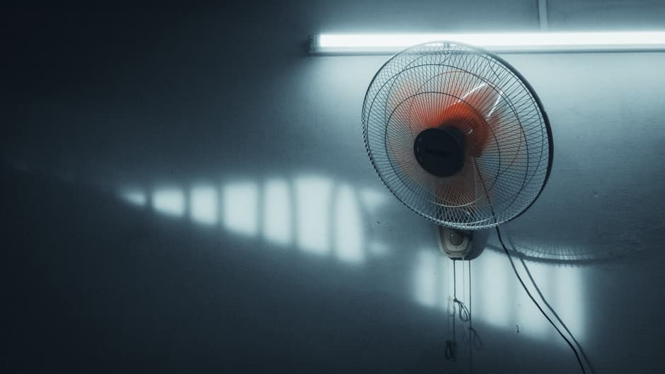 A calm interior with a wall-mounted fan and soft daylight