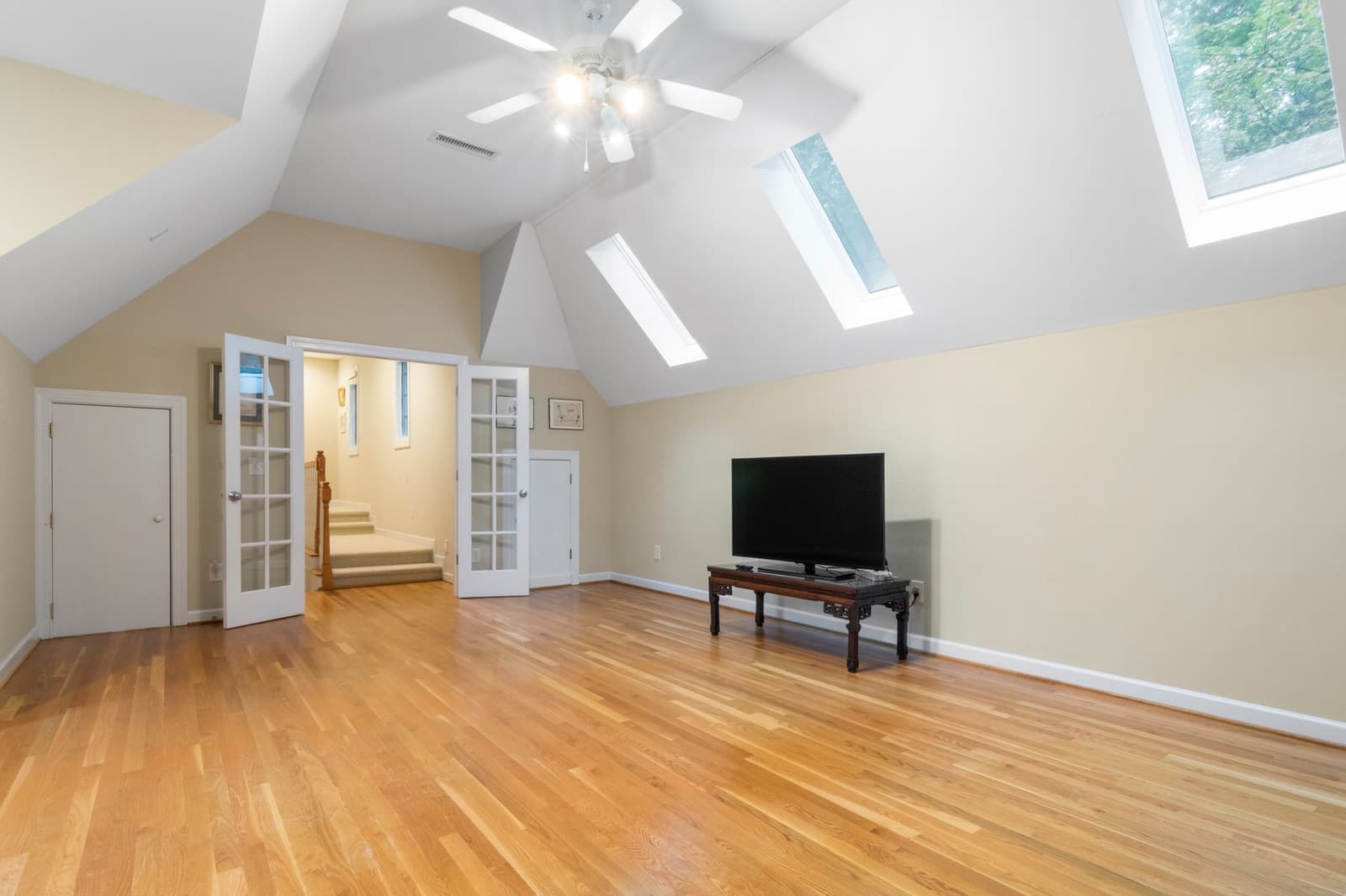 A bright converted attic room with skylights and wooden floors