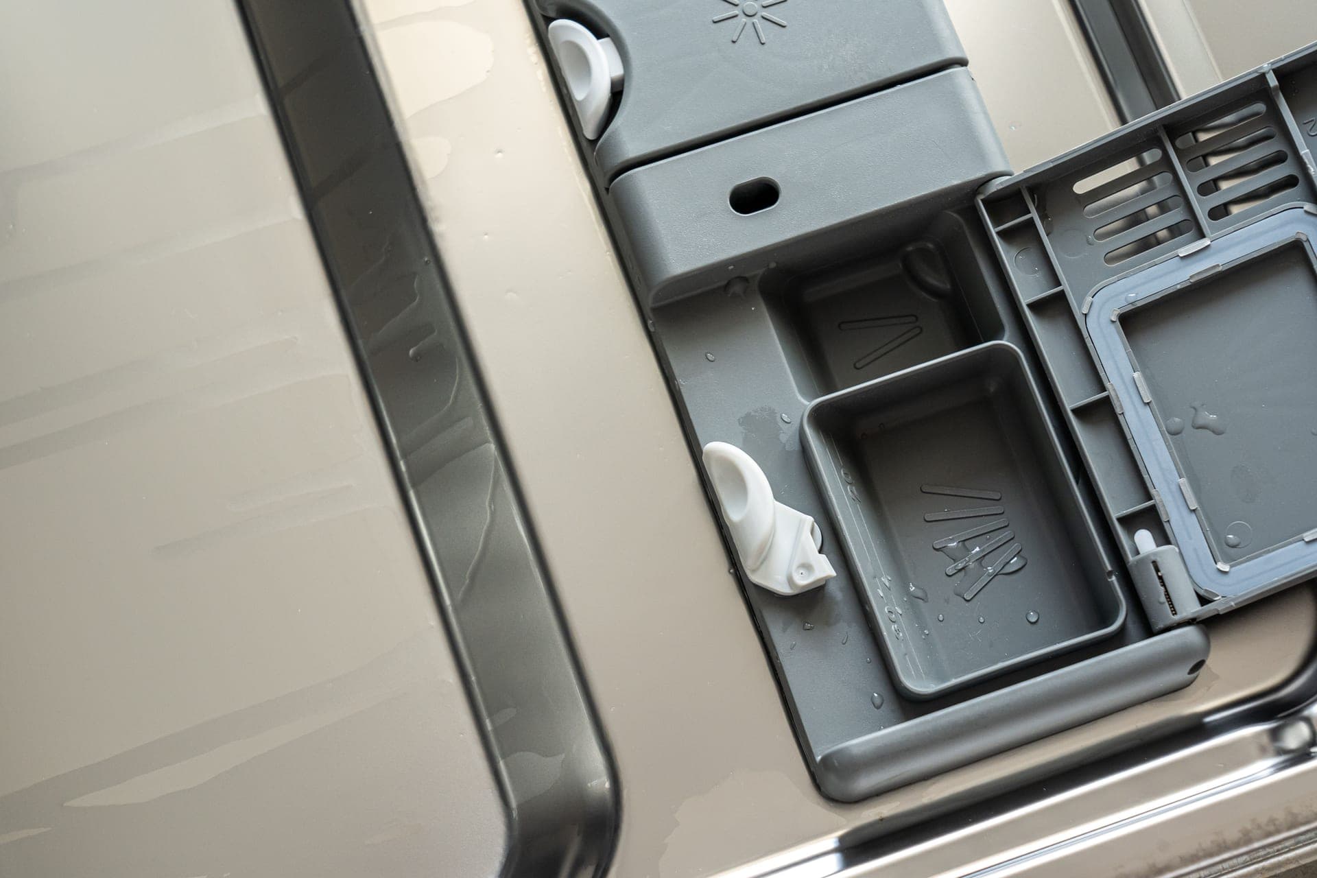 An open appliance compartment with water droplets