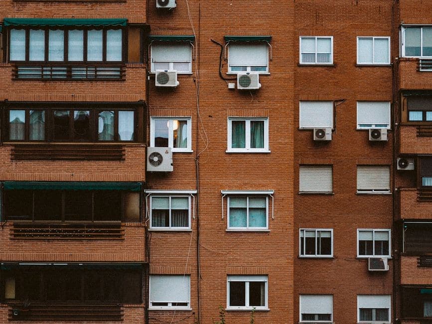 An orange brick apartment facade with rows of windows