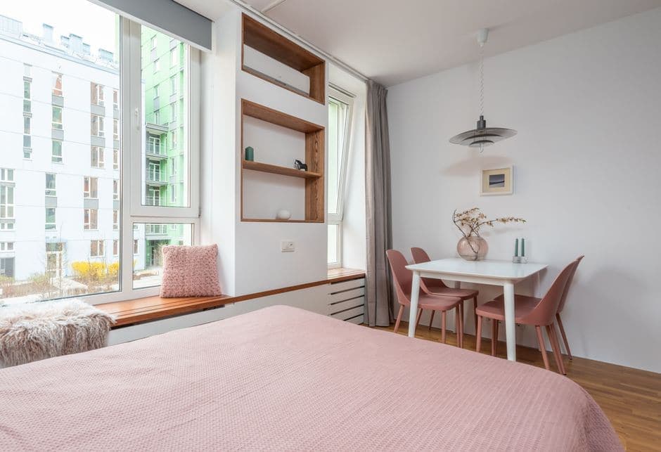 A contemporary bedroom with a soft bed beside a wide window