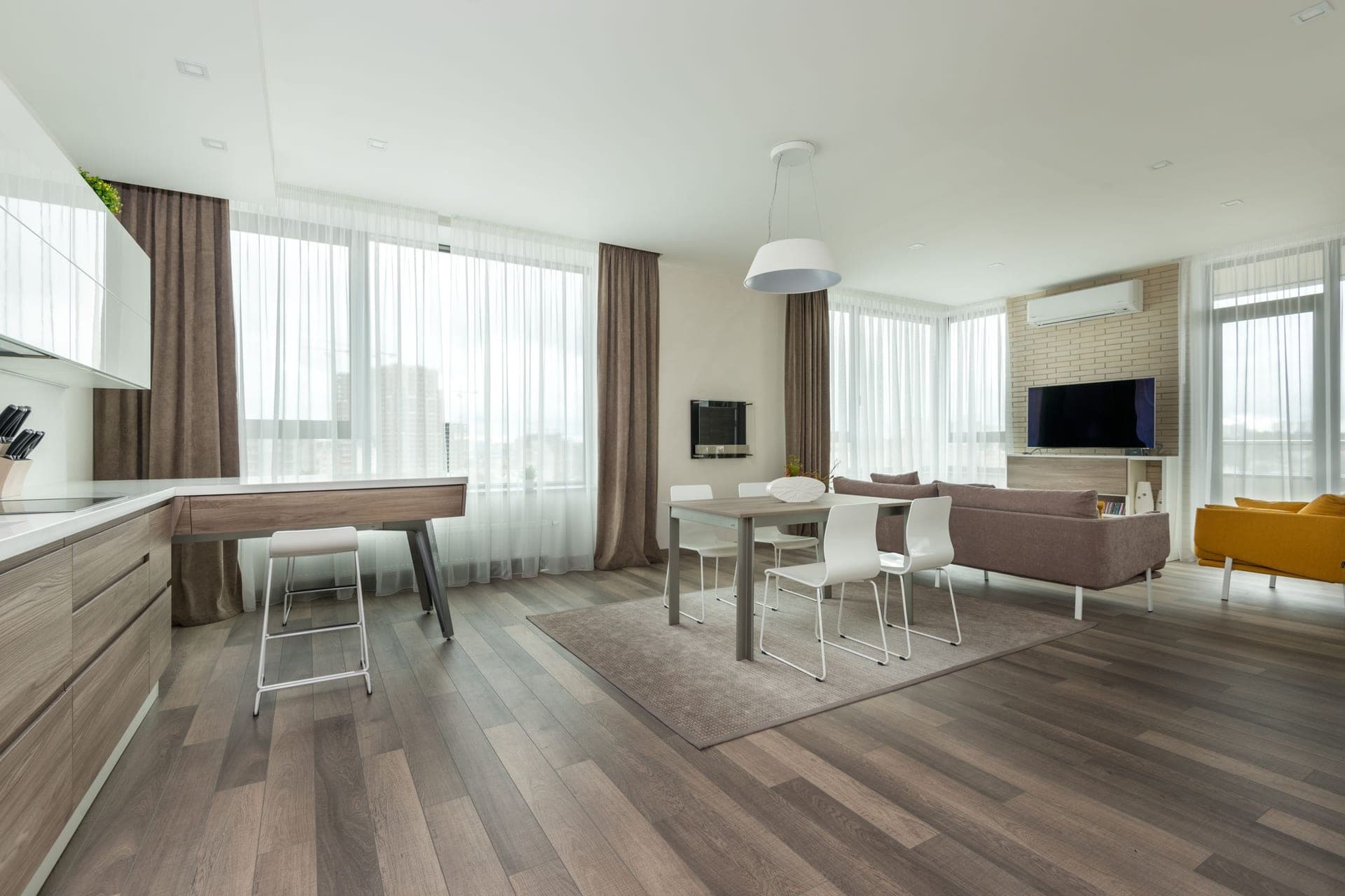 An open-plan room with a kitchen, dining table and sofa in one space