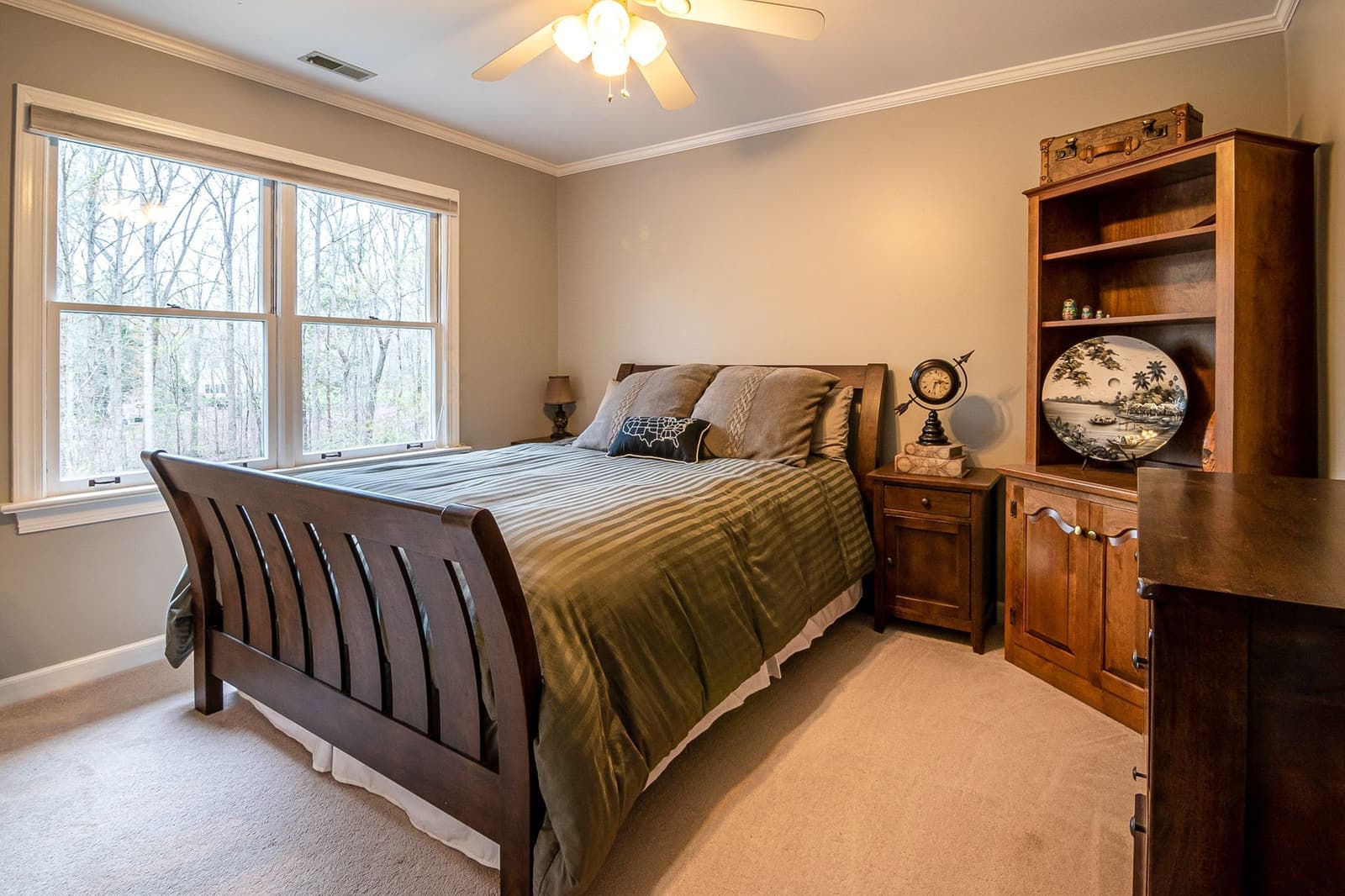 A quiet, warmly lit bedroom with a wooden bed frame and simple furniture