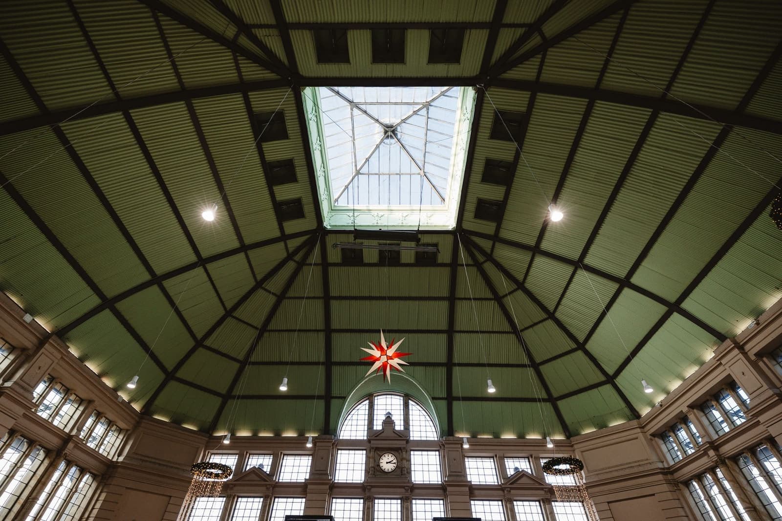 A spacious hall with a glass ceiling and a large hanging fixture