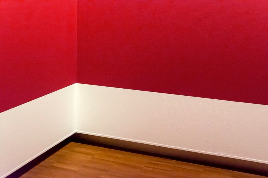 The corner of an empty room with a wooden floor