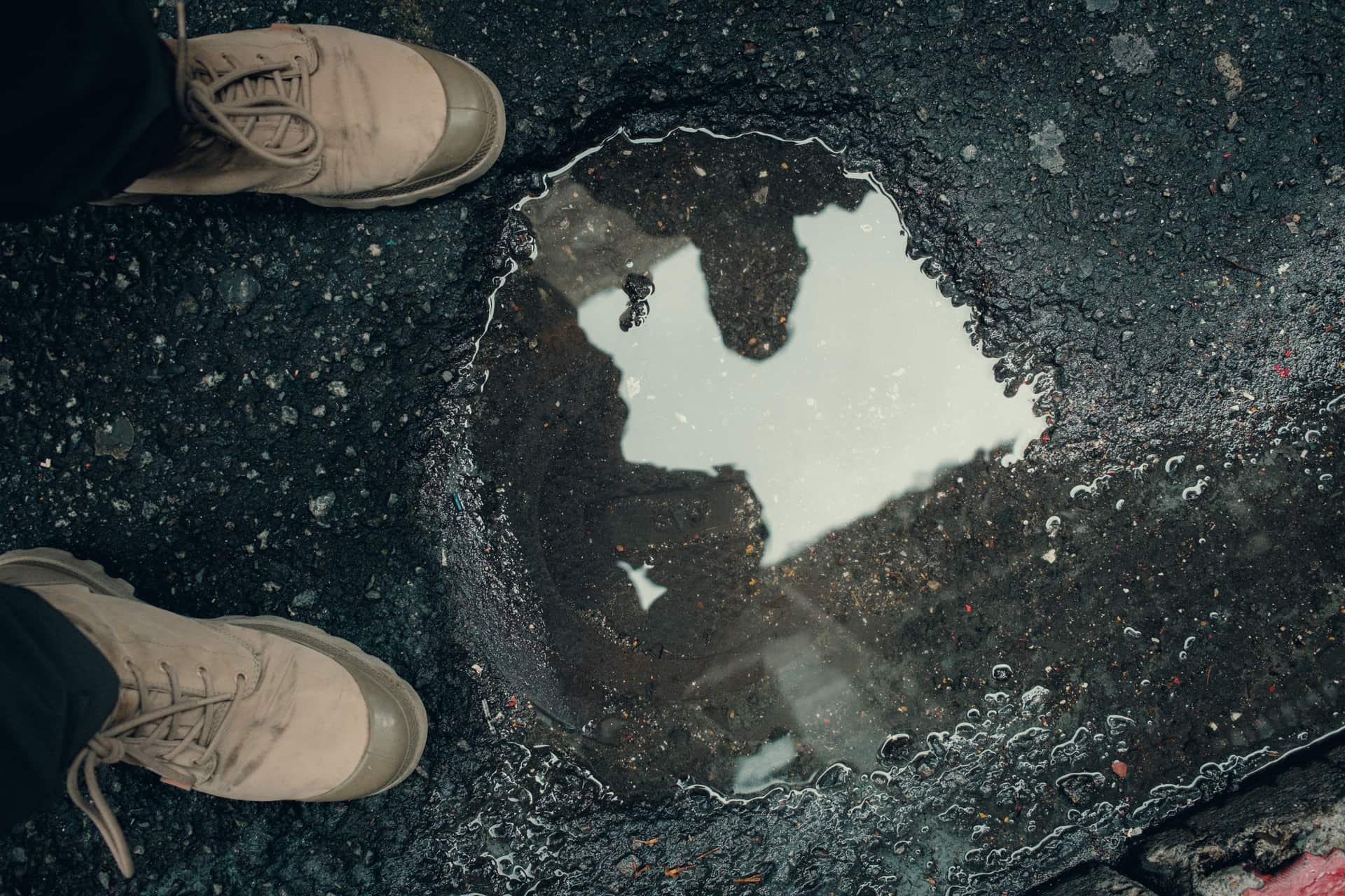 A puddle on an asphalt surface reflecting light
