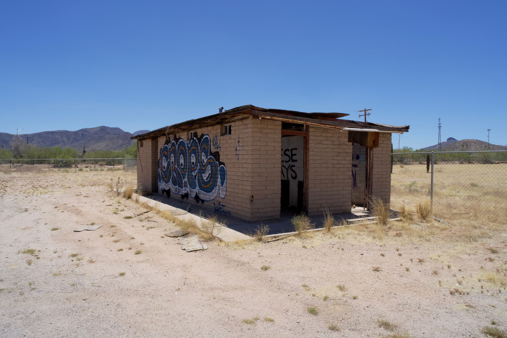 An open garage door with dry desert light outside and a portable evaporative cooler standing inside